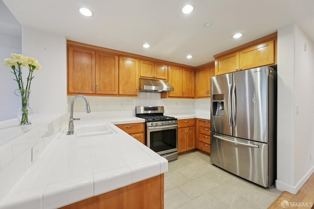 104 Diamond Cove Ter, San Francisco, CA 94134 - kitchen with stainless steel appliances, under cabinet range hood, tile countertops, brown cabinets, and recessed lighting