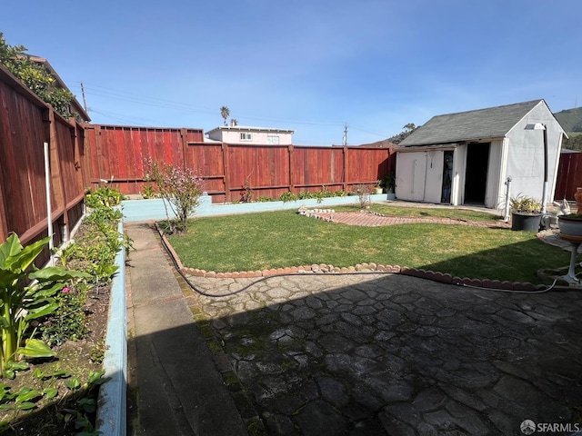 view of yard featuring a fenced backyard, a storage unit, and an outdoor structure