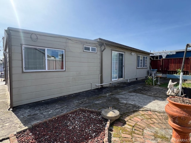 rear view of house featuring fence and a patio