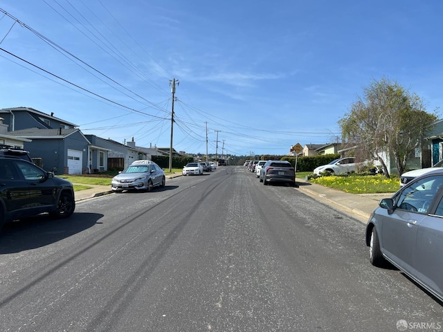 view of street with sidewalks, a residential view, and curbs