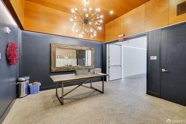 corridor with a towering ceiling and an inviting chandelier