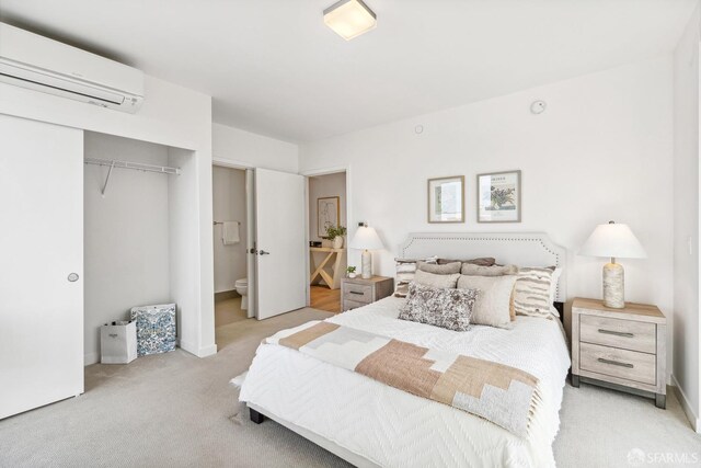 bedroom featuring a wall unit AC, light carpet, and a closet