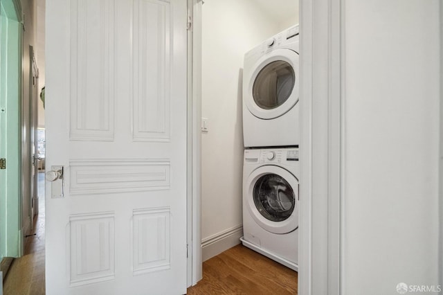 3511 23rd St Unit 1, San Francisco, CA 94110 - washroom featuring stacked washer / dryer and wood finished floors
