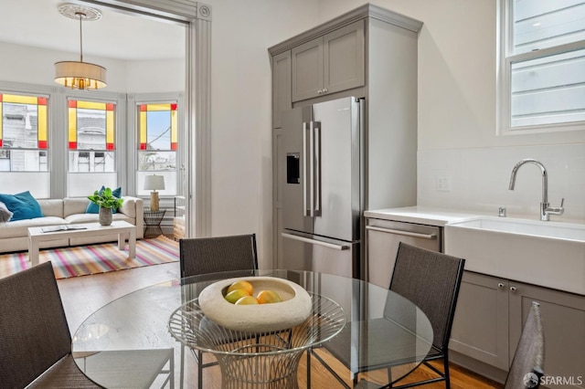 3511 23rd St Unit 1, San Francisco, CA 94110 - kitchen featuring appliances with stainless steel finishes, gray cabinetry, plenty of natural light, and tasteful backsplash