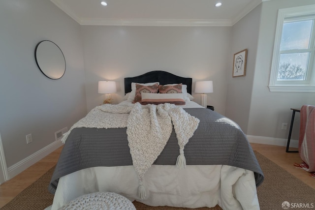 bedroom with ornamental molding and light wood-type flooring