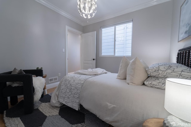 bedroom featuring crown molding, hardwood / wood-style floors, and an inviting chandelier