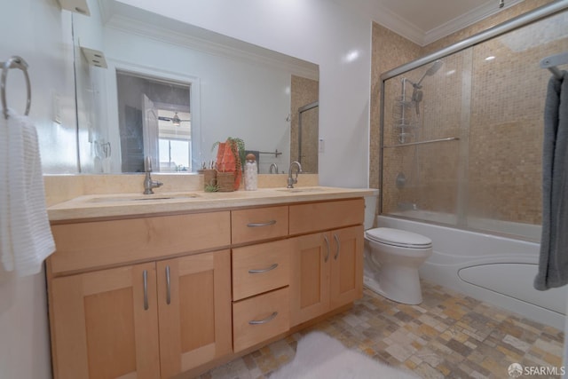 full bathroom featuring toilet, ornamental molding, vanity, and bath / shower combo with glass door