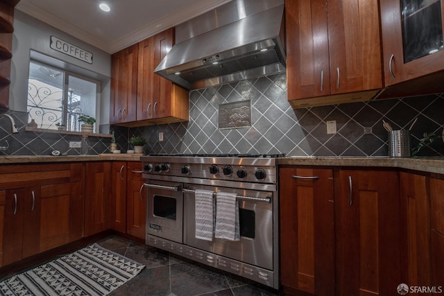 kitchen with tasteful backsplash, dark tile patterned flooring, range hood, and range with two ovens