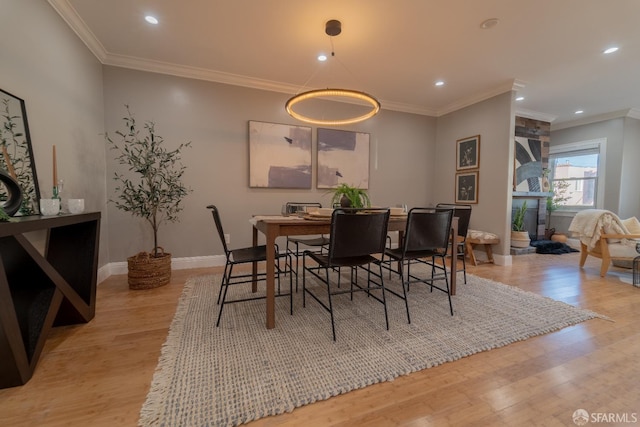 dining room featuring light hardwood / wood-style flooring and ornamental molding