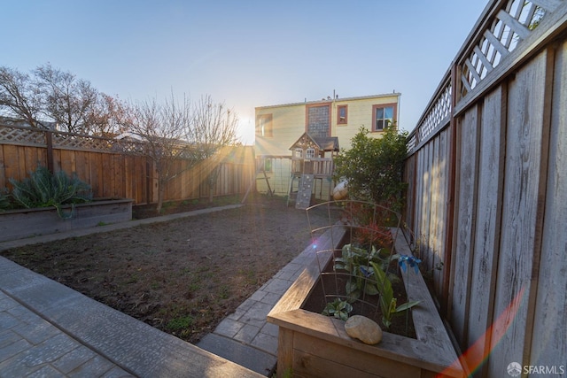 yard at dusk featuring a playground