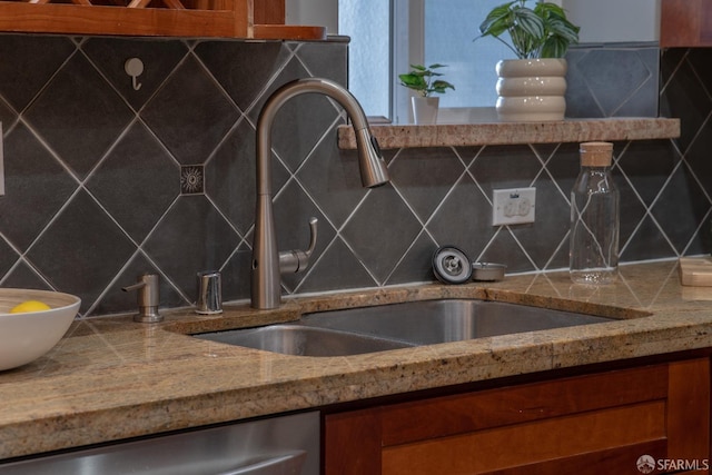 kitchen with tasteful backsplash, sink, and stainless steel dishwasher