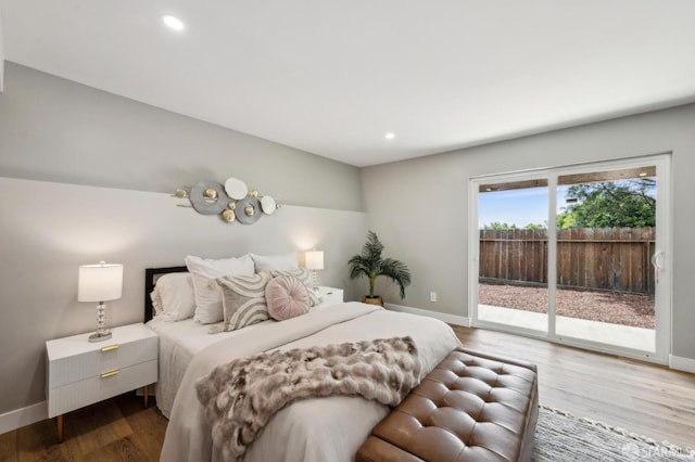 bedroom featuring baseboards, wood finished floors, recessed lighting, and access to exterior