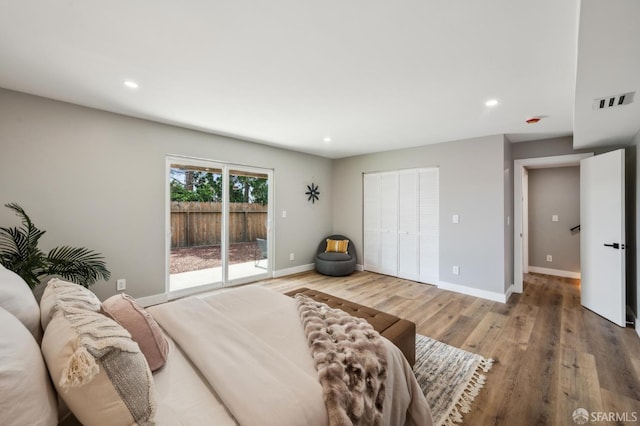 bedroom featuring baseboards, recessed lighting, wood finished floors, access to outside, and a closet