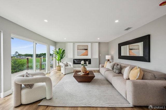 living area featuring recessed lighting, visible vents, light wood finished floors, and baseboards