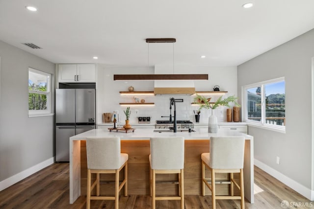kitchen with tasteful backsplash, open shelves, a healthy amount of sunlight, visible vents, and freestanding refrigerator