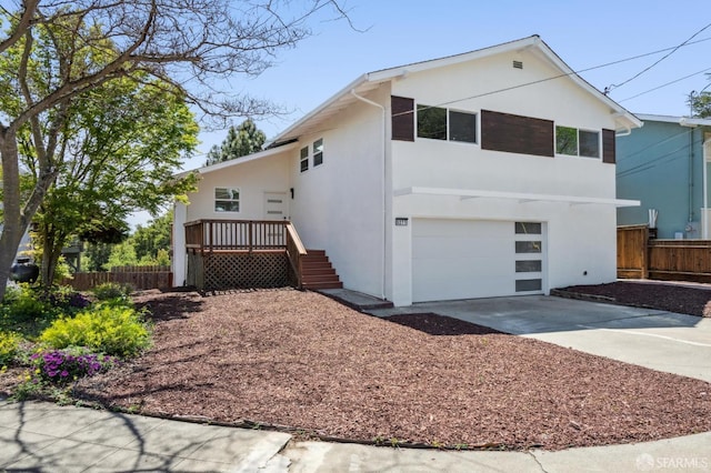exterior space with a garage, stucco siding, driveway, and fence