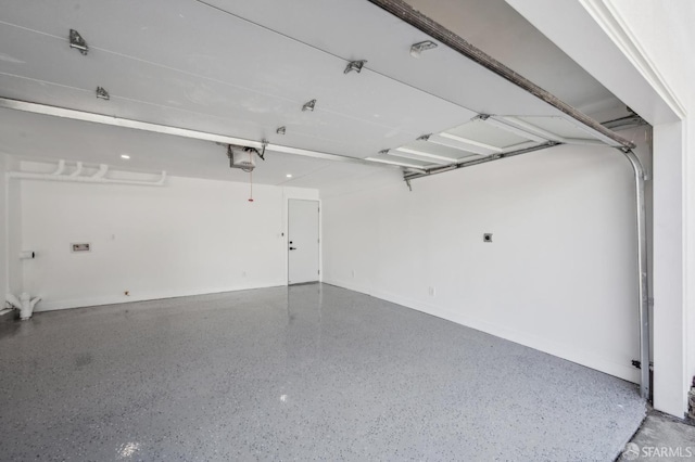 garage featuring a garage door opener and baseboards
