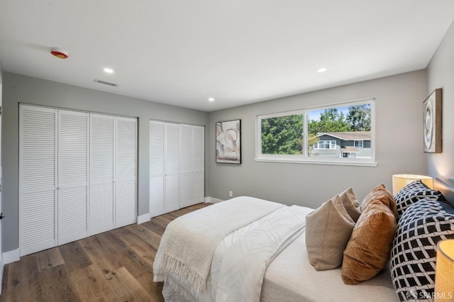 bedroom with recessed lighting, wood finished floors, visible vents, and baseboards