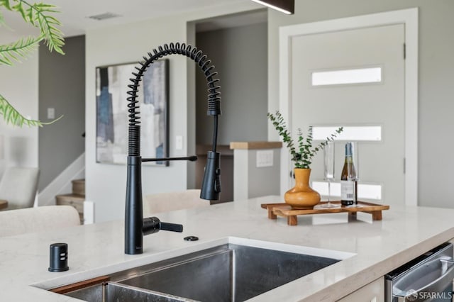 room details with stainless steel dishwasher and light stone counters