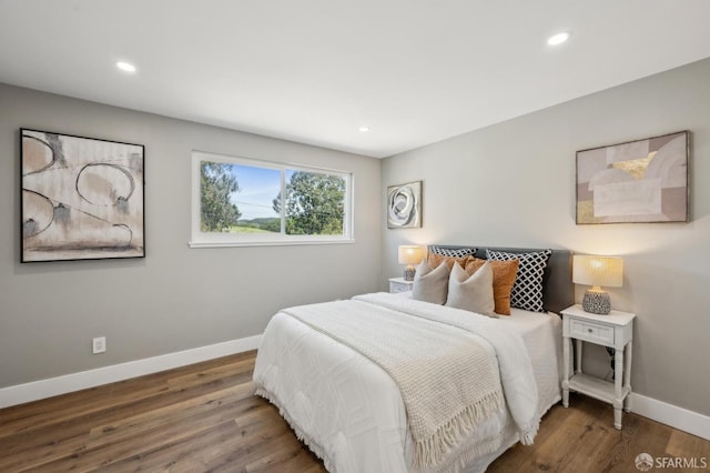 bedroom with recessed lighting, wood finished floors, and baseboards