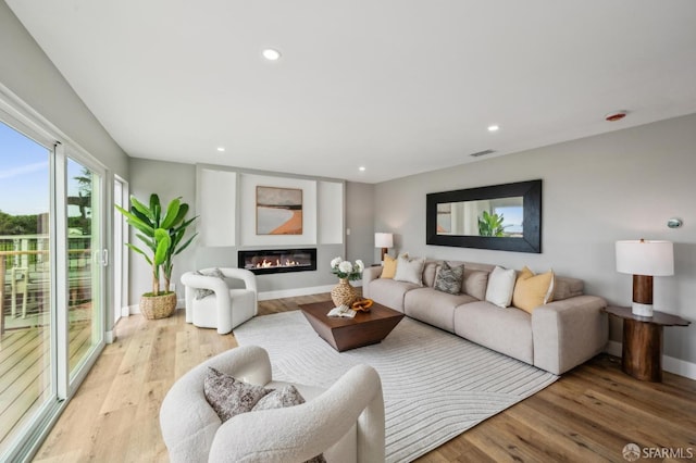 living area with recessed lighting, baseboards, visible vents, and light wood-type flooring