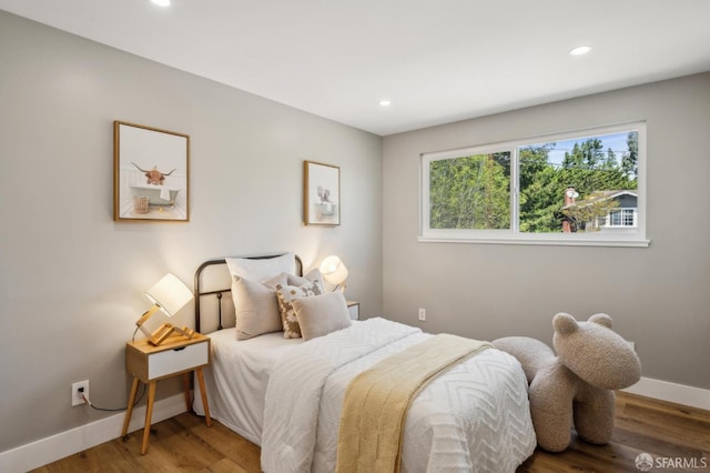 bedroom with baseboards, wood finished floors, and recessed lighting