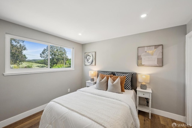 bedroom with dark wood finished floors, baseboards, and recessed lighting