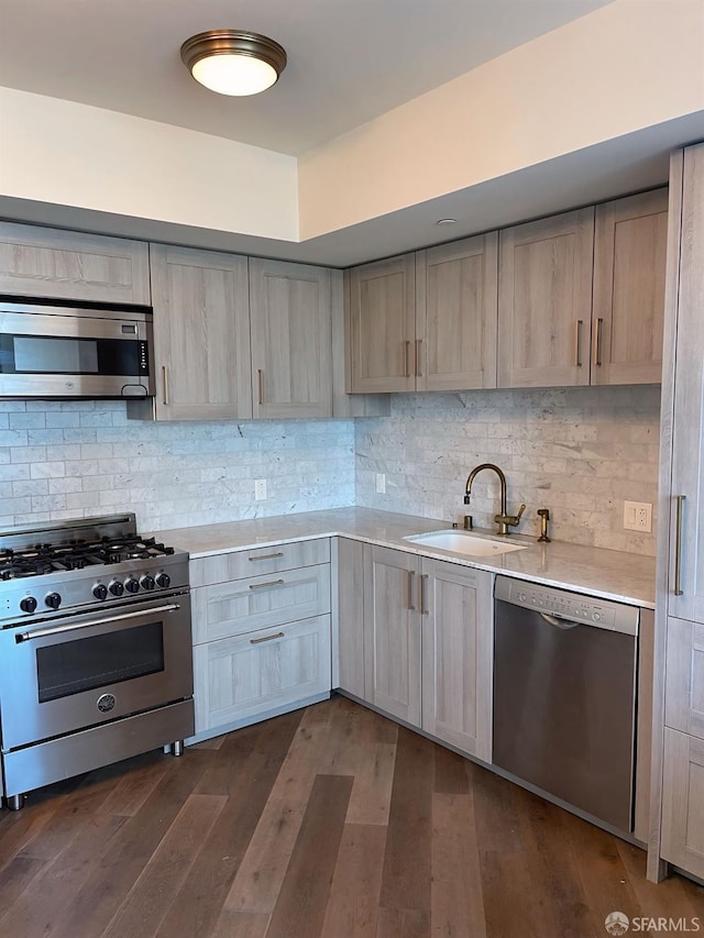 kitchen with backsplash, light countertops, stainless steel appliances, and a sink