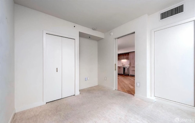 unfurnished bedroom with carpet flooring, baseboards, a closet, and visible vents