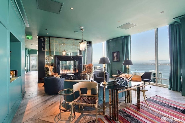 living area featuring a wall of windows, hardwood / wood-style floors, and a multi sided fireplace