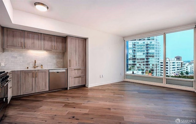 kitchen with a sink, a view of city, decorative backsplash, dark wood-style floors, and stainless steel dishwasher