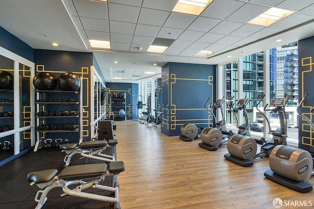 workout area with floor to ceiling windows and wood finished floors