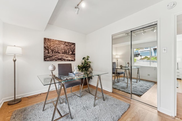 office space featuring wood-type flooring and track lighting