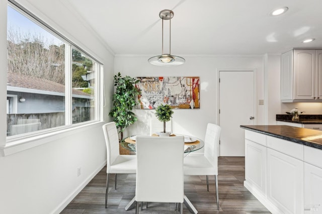 dining room featuring crown molding and dark wood-type flooring