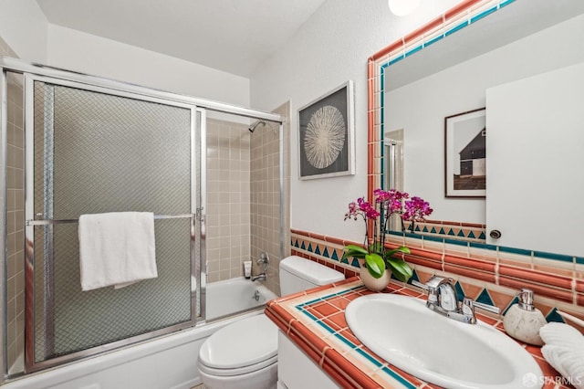 full bathroom with backsplash, combined bath / shower with glass door, vanity, and toilet