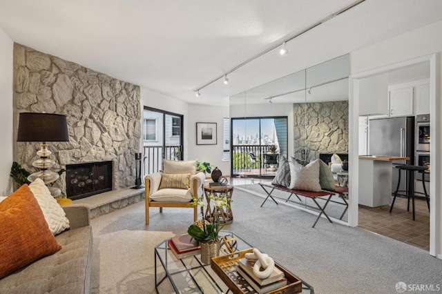 carpeted living room with a fireplace and track lighting