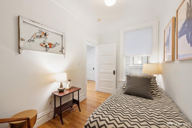 bedroom featuring light wood finished floors and baseboards