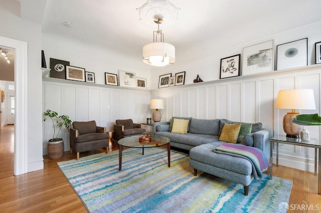 living area featuring light wood-style floors and a decorative wall