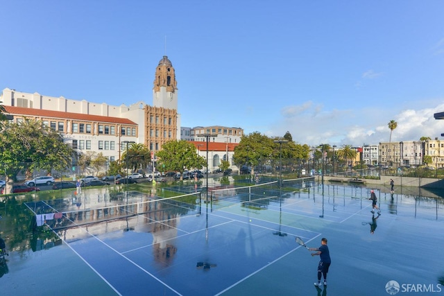 view of sport court featuring a water view and fence