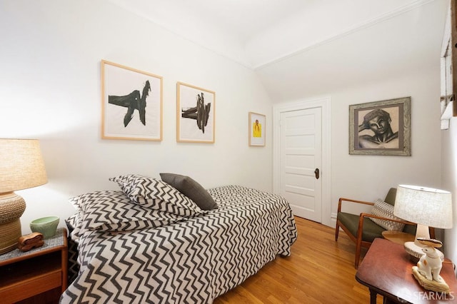 bedroom featuring lofted ceiling and light wood-style flooring