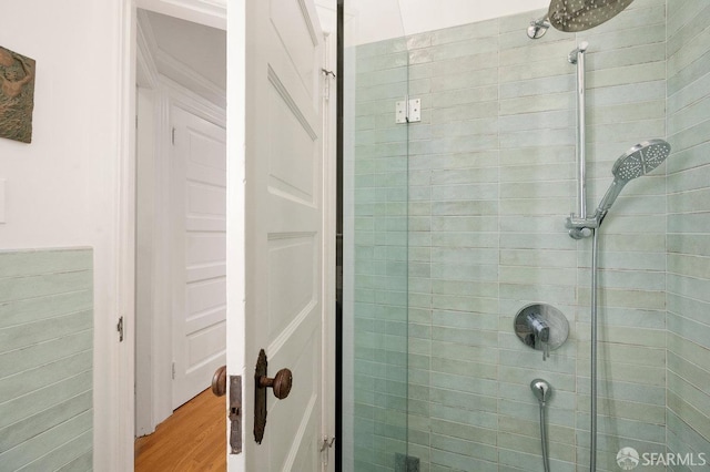 full bath with a stall shower and wood finished floors