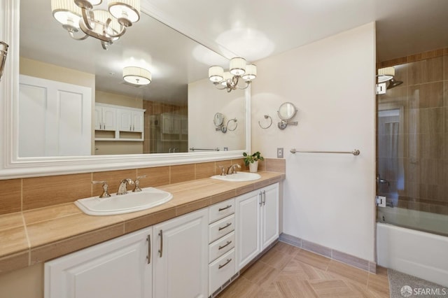 bathroom featuring tile patterned flooring, enclosed tub / shower combo, vanity, and an inviting chandelier