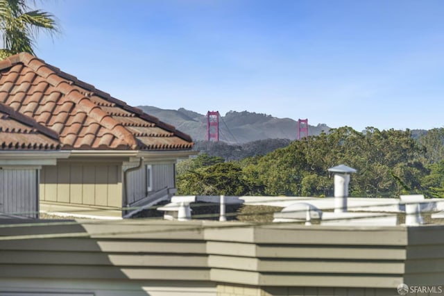 exterior space featuring a mountain view and a tiled roof