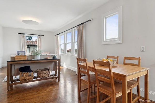 dining space featuring plenty of natural light, wood finished floors, and baseboards