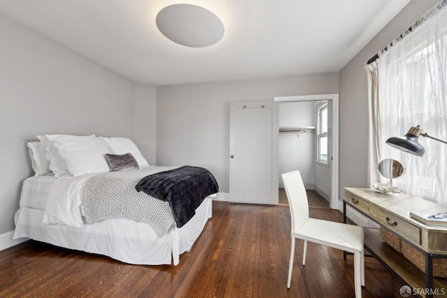 bedroom featuring a closet, baseboards, and wood finished floors