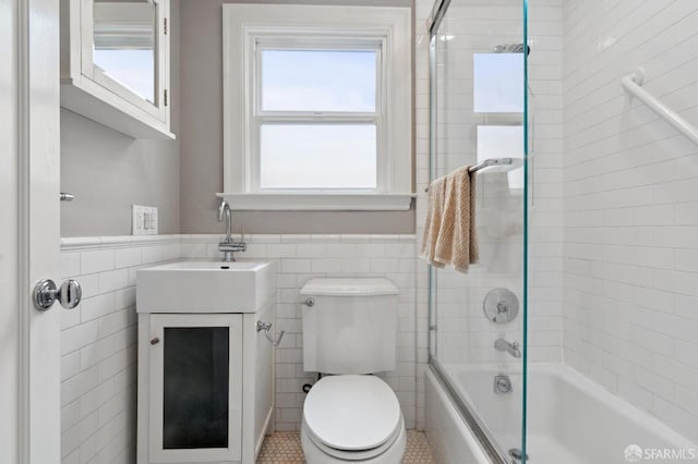 bathroom with shower / tub combination, vanity, tile walls, and wainscoting