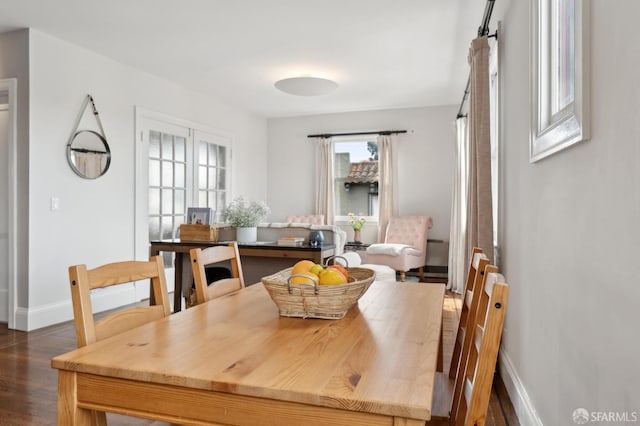 dining space featuring dark wood-style flooring and baseboards