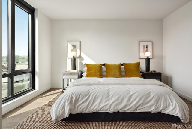 bedroom with hardwood / wood-style floors and multiple windows