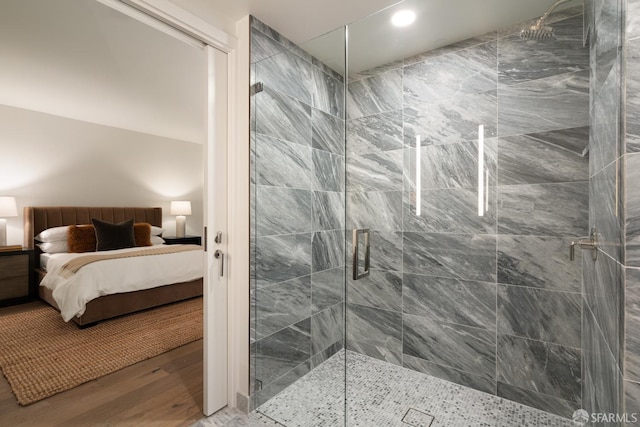 bathroom with hardwood / wood-style flooring and a shower with door