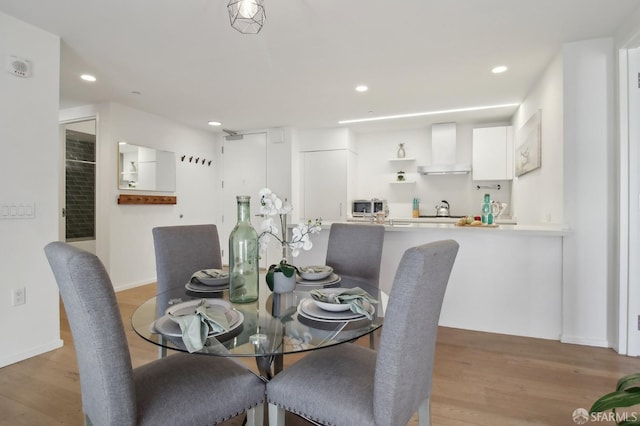 dining space with light wood-type flooring, baseboards, and recessed lighting